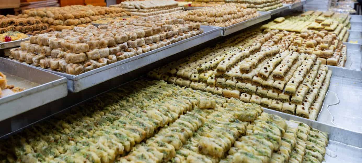 Rows of trays running the length of the counter, pistachio baklava in front