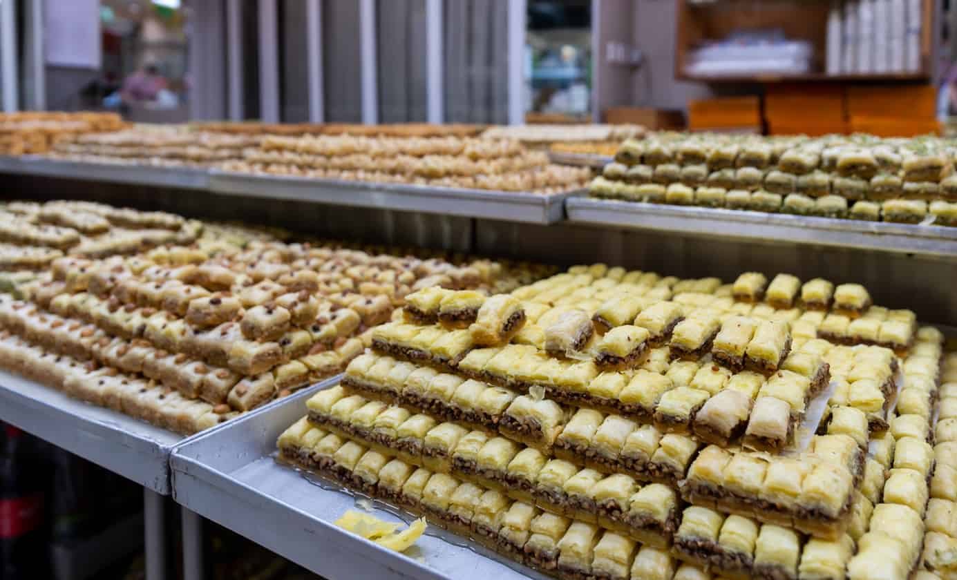 Pyramids of walnut and pistachio baklava on steel trays